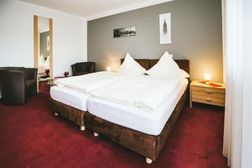 德尔布吕克Schultes Landhaus的一间卧室配有一张带白色床单的大床