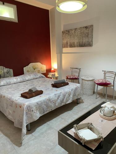 布林迪西Il vicoletto的一间卧室配有一张床和两张桌子及椅子