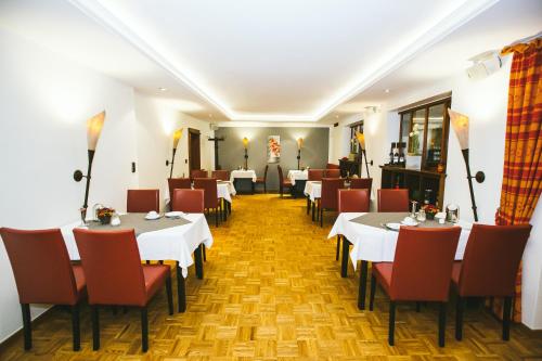 德尔布吕克Schultes Landhaus的一间设有白色桌子和红色椅子的餐厅