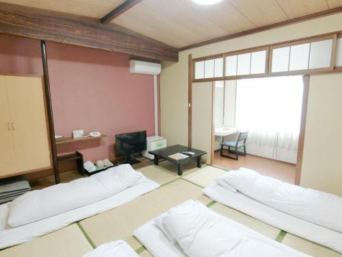别府野上本馆日式旅馆的带三张床和电视的客房