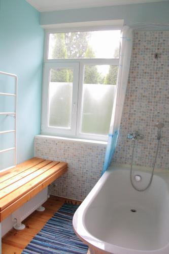 尤尔马拉Family Apartments的带浴缸的浴室和窗户。
