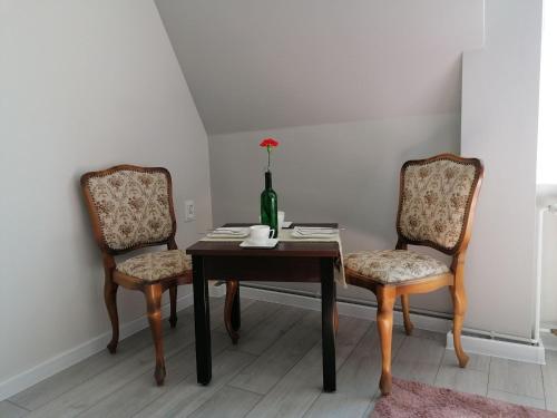 乌斯特卡Pokoje Alicja Ustka的餐桌、两把椅子和一瓶葡萄酒