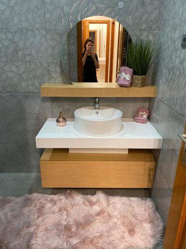 阿威罗Vagueira casa férias的一位在浴室里拍下水槽照片的女人