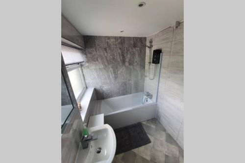埃尔斯米尔港Entire House - Cheshire Oaks/Ellesmere Port的浴室配有盥洗盆、卫生间和浴缸。