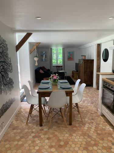 滨海圣佩Le Logis K, le charme au cœur de Saint Pair的一间带桌子和白色椅子的用餐室