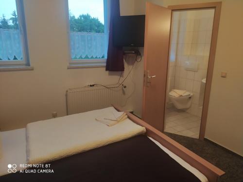 沃尔加斯特ALTE MOLKEREI Wolgast的客房设有一张床和一间带卫生间的浴室
