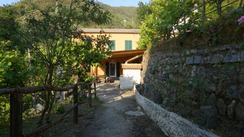 斯培西亚Agriturismo U muinettu的围栏房子旁边的石墙