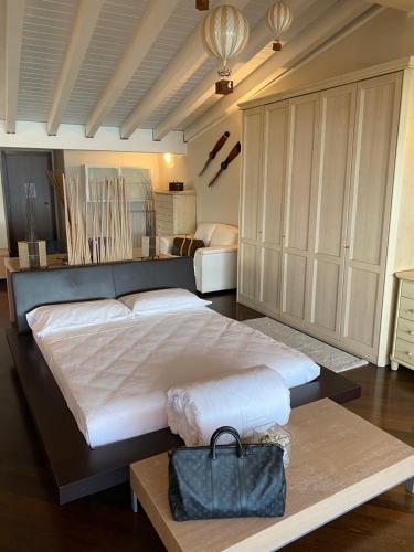 代森扎诺-德尔加达Molino Apartments的大卧室配有一张大床,上面装有钱包