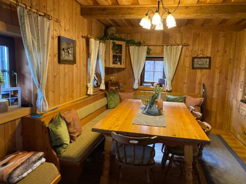 米尔施塔特Reinwalds Almhütte的一间带木桌和沙发的用餐室