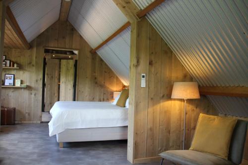 欧非博格Inn The Woods - Private Stay的阁楼卧室配有床和椅子