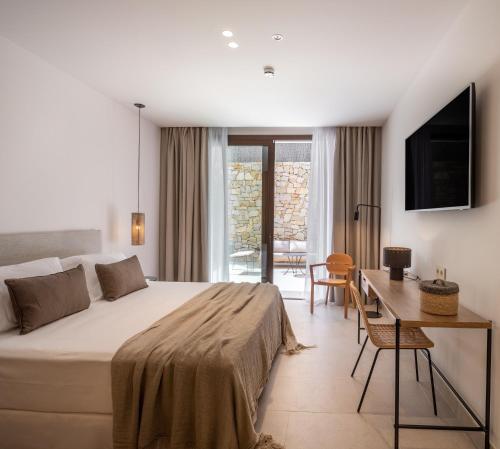 萨阿拉德洛斯阿图内斯Hotel Porfirio Picota - Adults Recommended的一间卧室配有一张床、一张书桌和一台电视
