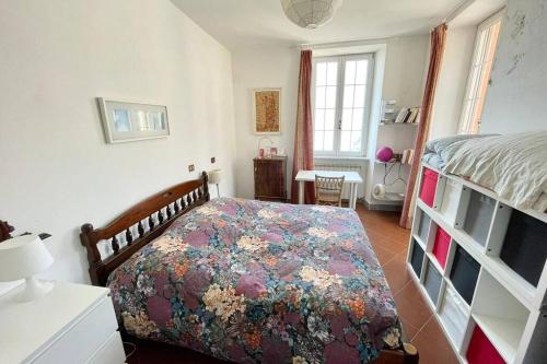 弗拉穆拉Framura, Ampio appartamento con terrazzo vista mare的一间卧室配有一张带花卉床罩的床