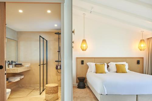 科利尤尔Les Roches Brunes的一间带白色床的卧室和一间浴室