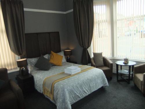 布莱克浦Dewsbury House的一间卧室配有一张床、一把椅子和窗户。