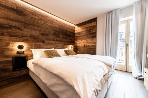 摩德纳迪-坎皮格里奥ALPINE DAYS Mountain Home的一间卧室设有木墙和床