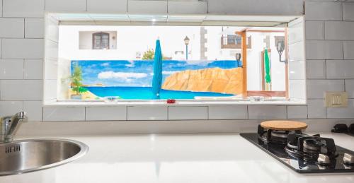 蓬塔穆赫雷斯Romantico con piscina privada solo para ti的厨房设有水槽和窗户。