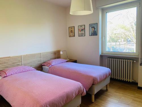 代森扎诺-德尔加达Horto Terapeutico Home的带窗户的客房内的两张床