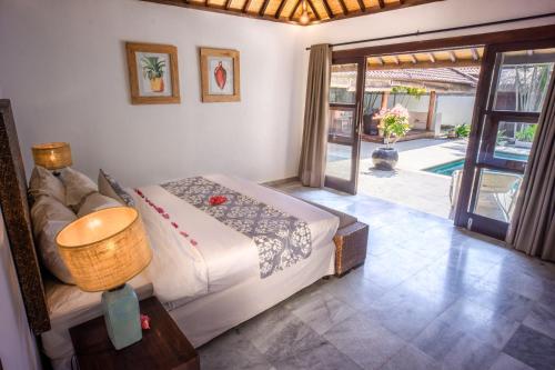 吉利特拉旺安吉利别墅酒店的一间卧室设有一张床,并有通往庭院的门