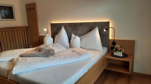 因斯布鲁克豪斯奥林匹亚公寓酒店的一张带白色床单和枕头的床