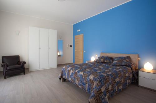 特拉帕尼独一蓝光住宿加早餐酒店的一间卧室配有一张床和一把椅子
