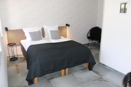 哈泽斯莱乌Hotel Petite B&B的一张带黑色毯子和白色枕头的床