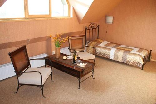 帕普Atpūtas komplekss "Pūķarags"的卧室配有一张床和一张桌子及椅子