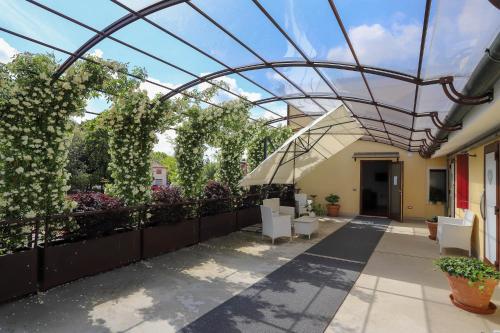 奎托·迪·特雷维索LOCANDA RIGHETTO的一个带椅子和植物的庭院的玻璃屋顶