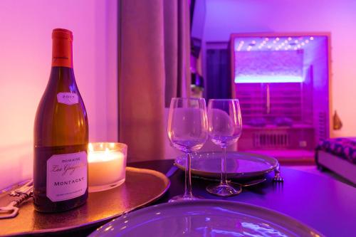 第戎Spa Edelweiss的一张桌子上摆放着一瓶葡萄酒和两杯酒杯