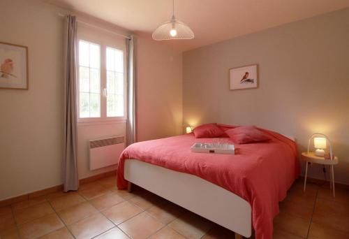 Naujac-sur-MerDomaine du Flamand - Gîtes du Pin Sec côté OCEAN的一间卧室配有一张带红色毯子的床和窗户。