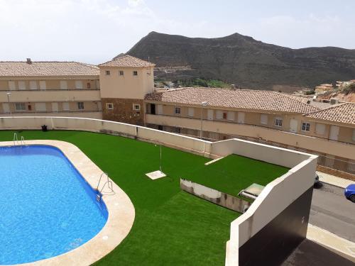 比卡尔Casas Nuestras II Andalucia La Envia Golf piscinas de verano y climatizada en invierno, fitness center wifi y parking disponible con reserva的享有带大型游泳池的建筑景致