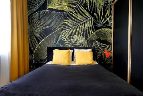 科沙林W&K Apartments - Gold Suite的一间卧室配有一张带两个黄色枕头的床