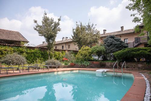 Truccazzano罗坎达圣安娜住宿加早餐旅馆的一座带椅子的庭院和一座建筑中的游泳池