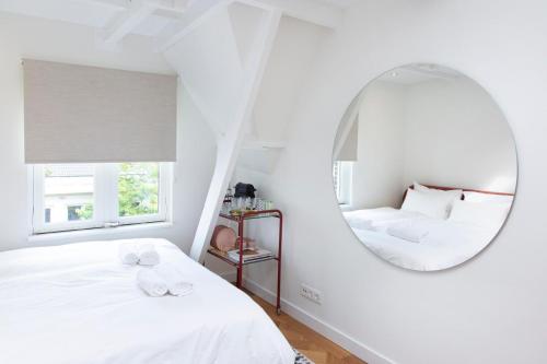 阿姆斯特丹Trendy 2 bedroom accommodation on perfect location的一间白色卧室,配有镜子和两张床