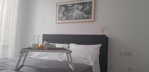 马拉加Acogedor Apartamento en el Corazón de Málaga的一间卧室配有一张床铺,旁边设有桌子