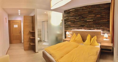 YspertalGasthof-Hotel zur Linde的一间卧室设有黄色的床和砖墙