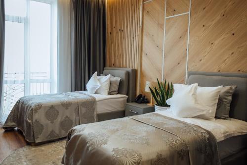 敖德萨Alice Place Hotel的酒店客房设有两张床和窗户。