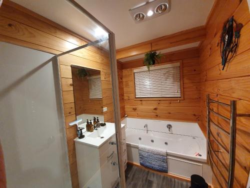 罗托鲁瓦Folia Domus NZ, Redwoods, MBT的带浴缸、水槽和浴缸的浴室