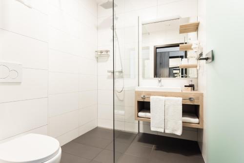 BöheimkirchenHotel Smart Liv'in的带淋浴、卫生间和盥洗盆的浴室