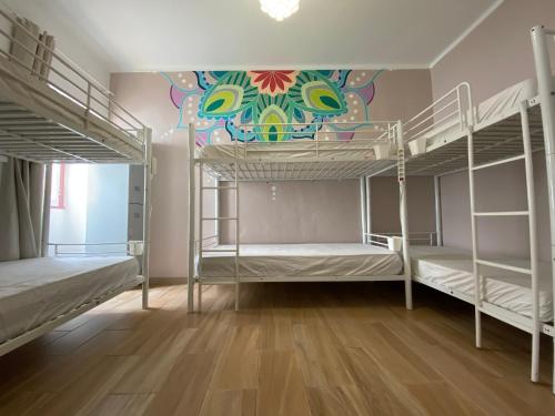 阿尔布费拉奥兰奇特莱斯旅舍的客房设有带壁画的双层床。