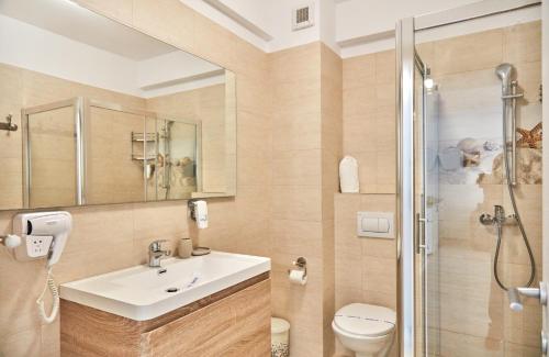 北马马亚-讷沃达里Apartments Excelsior Mamaia Nord的一间带水槽、卫生间和淋浴的浴室