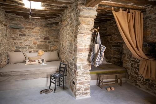 MésiOnos Eco Living的砖墙内的房间,配有床和椅子