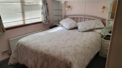 法灵登Huntersfield Chalet的一间卧室配有一张带两个枕头的床