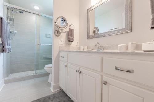巴拿马城海滩Three Palms Tree Home的白色的浴室设有水槽和淋浴。
