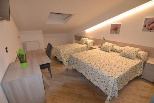 乌尔比诺B&B Canavaccio的酒店客房设有两张床和一张桌子。
