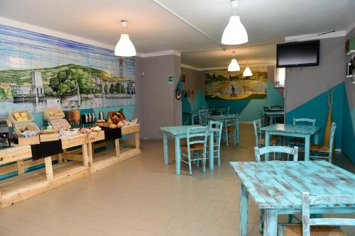 韦尔巴尼亚韦尔巴尼亚青年旅馆的一间设有桌椅的餐厅,墙上挂着壁画