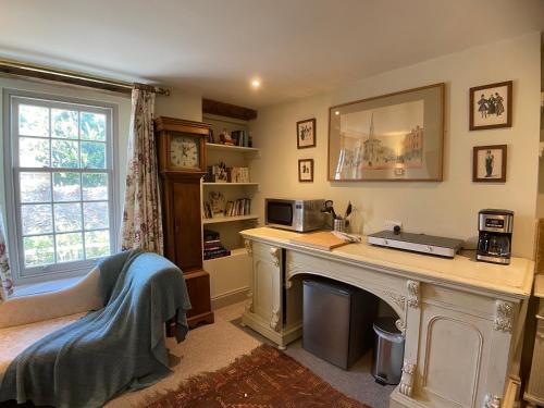 布里克瑟姆HORTUS HOUSE - Regency style apartment with attached parking的一个带书桌和壁炉的家庭办公室