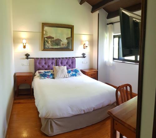 里瓦德塞利亚Amaicha Hotel Rural的一间卧室配有一张大床和紫色床头板