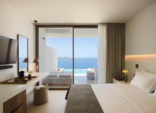 MytakasDomes White Coast Milos, Adults Only - Small Luxury Hotels of the World的酒店客房设有一张床,享有海景。
