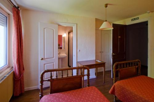 莱昆韦里阿耶斯塔兰一号旅馆的一间设有床和桌子的房间和一间房间