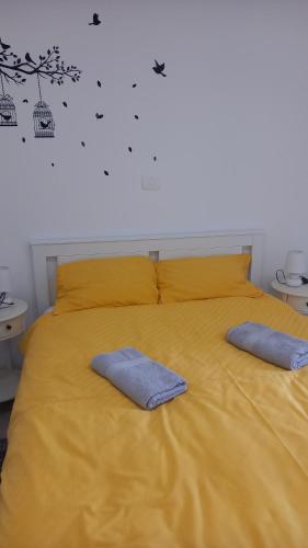 格罗日年App Parenzana的一张黄色的床,上面有两个蓝色的枕头